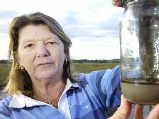 Exhibit A: Ann Love holds up a water sample from the accident site that was deemed clean. A fuel truck overturned and lost 7000 litres of petrol and 7500 litres of diesel along the Bruxner Highway between Lismore and Casino. Picture: Jerad Williams