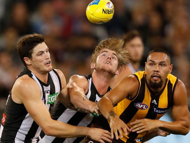 Jack Crisp and Sam Murray of the Magpies and Jarman Impey of the Hawks compete for the ball at the MCG last Saturday. Picture: Michael Willson/AFL Media/Getty Images