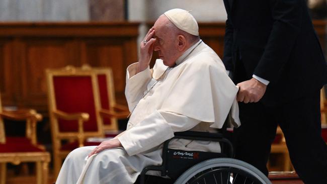 Pope Francis arrives on a wheelchair by the coffin of Australia's Cardinal George Pell. Picture: AFP