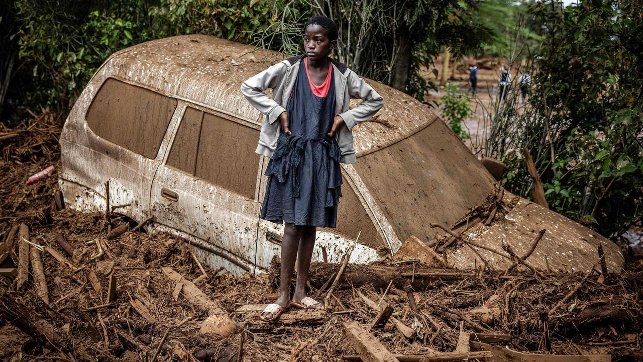 A girl stands beside a car buried in mud in Kamuchiri, following a dam burst after devastating floods and torrential rains that have killed at least 45 people in Kenya’s Rift Valley. Picture: Luis Tato/AFP