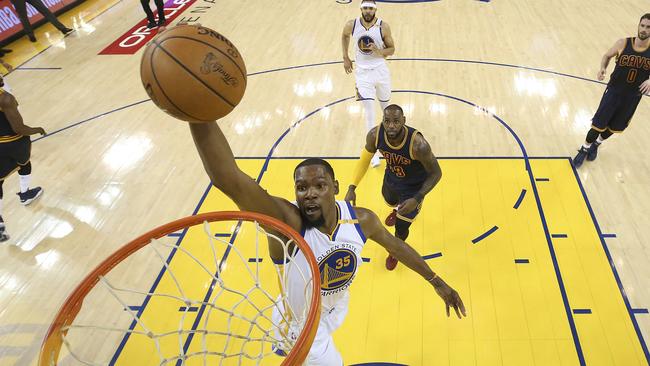 Golden State forward Kevin Durant dunks in front of Cleveland Cavaliers star LeBron James