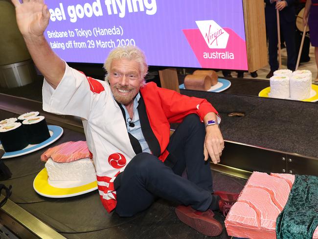 Eel good flying, Sir Richard Branson takes a ride on a makeshift sushi train, Virgin Australia promotes their new route from Brisbane to Japan, Brisbane Airport. Photographer: Liam Kidston.