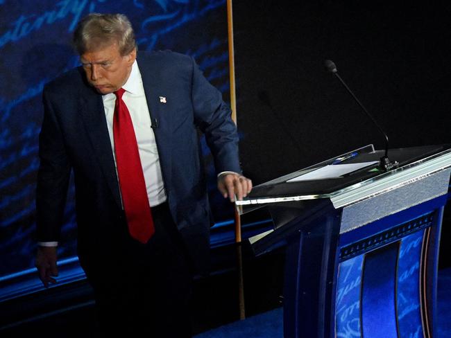 Former US President and Republican presidential candidate Donald Trump walks away during a commercial break as US Vice President and Democratic presidential candidate Kamala Harris take notes during a presidential debate at the National Constitution Center in Philadelphia, Pennsylvania, on September 10, 2024. (Photo by SAUL LOEB / AFP)