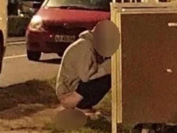 A man photographed squatting behind a row of rubbish bins at East Esplanade Reserve, Manly. Picture: Supplied