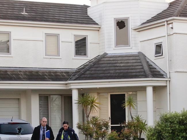 An upstairs window and car are visibly damaged at a Port Melbourne home that was peppered with bullets this morning. Picture: Hamish Blair