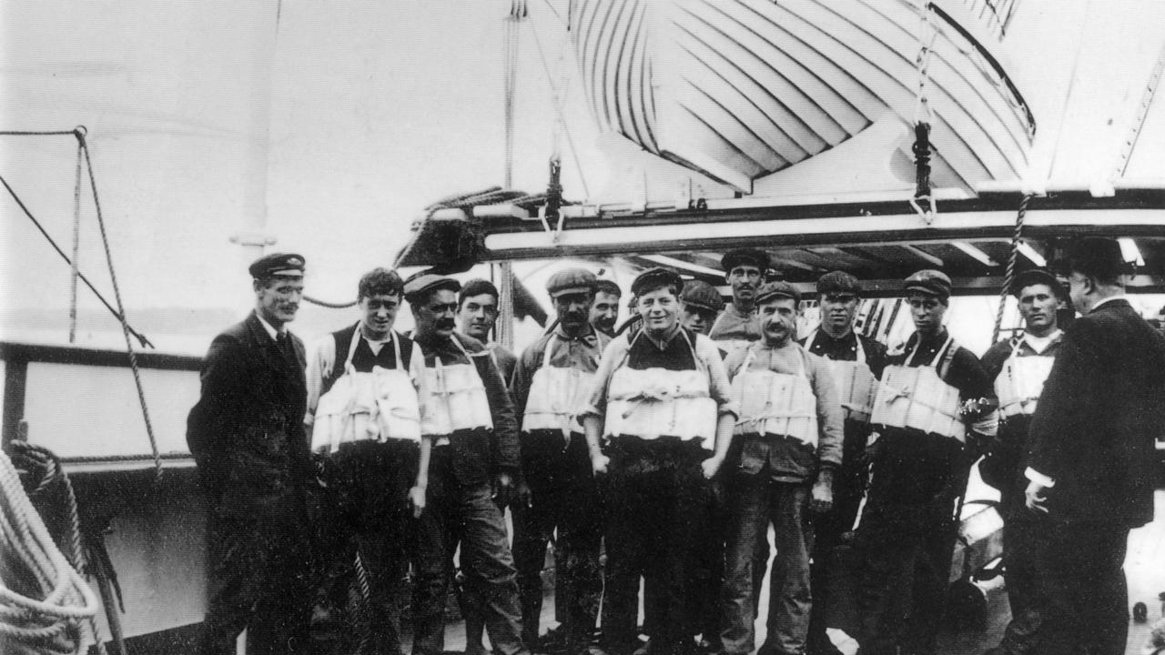 A lifeboat drill and the inspection of life-jackets on the Titanic.