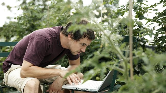 Man working on laptop on roof terrace