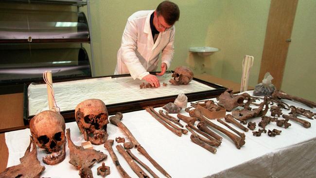 Alexei Nikitin, chief of the group of scientists who examined the exhumed bones of the executed Nicholas II and his family, lays out the vertebrae belonging to the Tsarina's chambermaid, Anna Demidova, in the central forensics lab in Yekaterinburg in 1998. The skulls in the foreground are Tsar Nicholas (right) and the Tsarina. Picture: AP