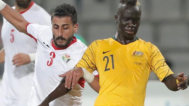 Socceroo Awer Mabil is marked by Jordan's defender Tareq Khattab (C) during the Group B FIFA World Cup 2022 and 2023 AFC Asian Cup qualifier in Amman last year.