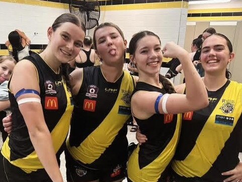 A show of strength. Lucy Riddle, second from the right flexing her muscles, with teammates after the match. Note the blue and white arm bands.