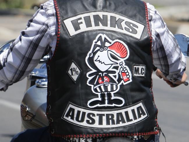 Finks Motorcycle Club and Longriders Motorcycle Club and other clubs on a run around Adelaide to visit graves of mates. Rear view of bikie wearing jacket riding on his motorcycle.