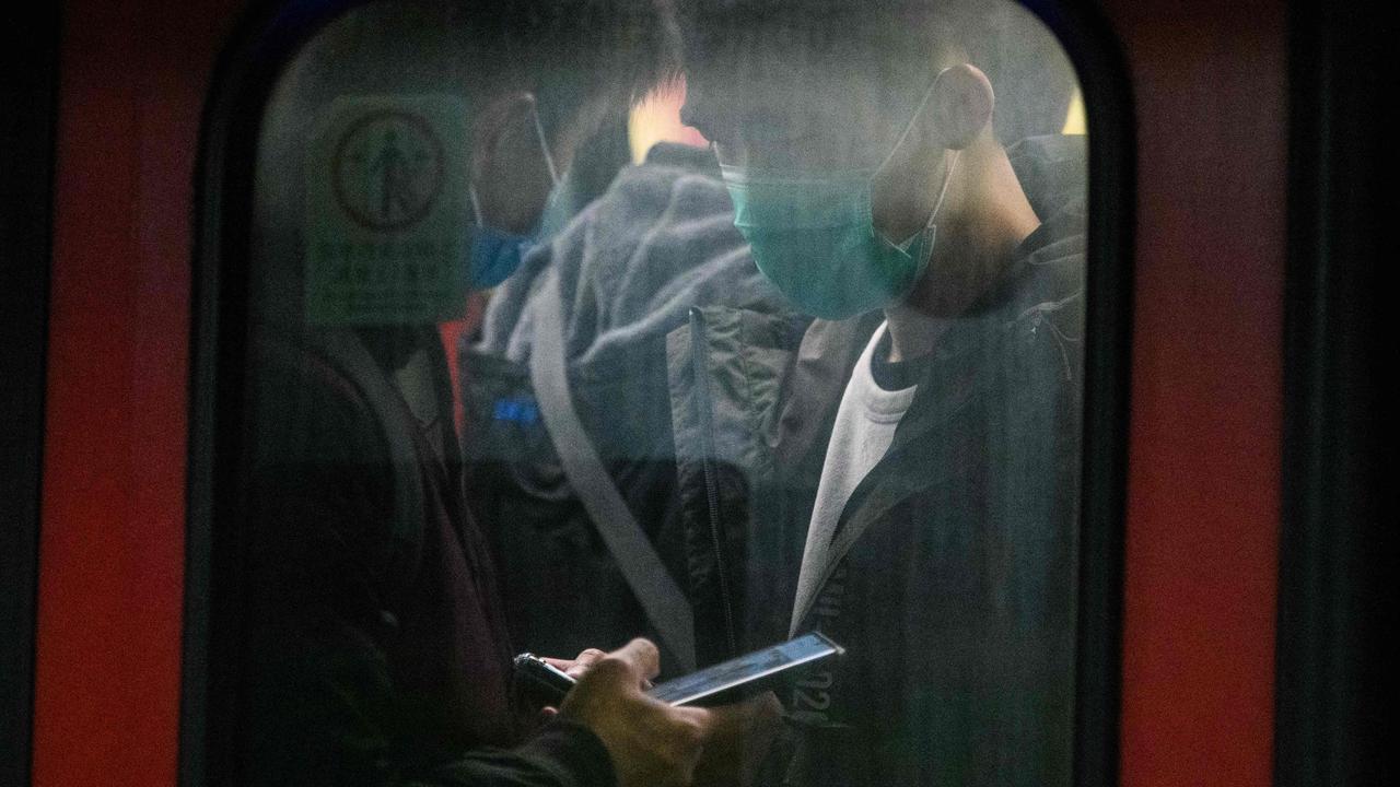 Passengers wear protective face masks in a Hong Kong-bound train at Lo Wu MTR station, hours before the closing of the Lo Wu border crossing in Hong Kong yesterday. Picture: Anthony Wallace/AFP