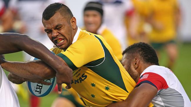 Kurtley Beale of the Wallabies tries to fight his way between two United States players.