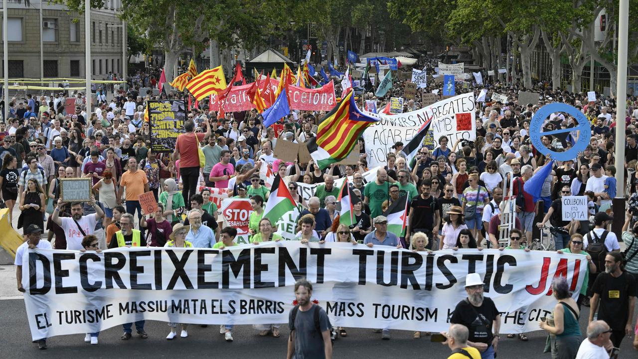 Demonstrators hold signs reading 'Turism decrease' on Barcelona's Las Ramblas alley, on July 6. Picture: Josep Lago / AFP