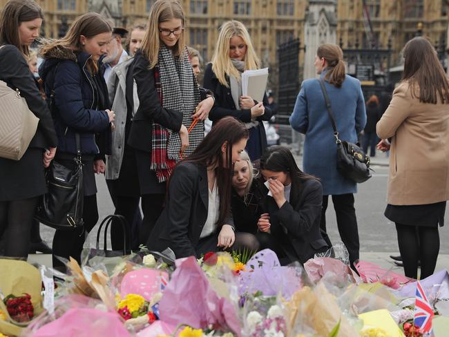 LONDON, ENGLAND - MARCH 29:  People look at floral tributes left for the victims of last week's Westminster terrorist attack on March 29, 2017 in London, England. Faith Leaders head up a vigil including members of the public and police officers on Westminster Bridge exactly one week after Khalid Masood ploughed a hired car into people crossing Westminster Bridge, killing three. Masood gained entry to the grounds of the Houses of Parliament stabbing PC Keith Palmer to death before he was shot dead by armevd police.  (Photo by Dan Kitwood/Getty Images)