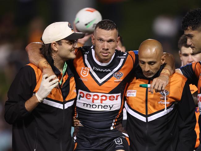 SYDNEY, AUSTRALIA - FEBRUARY 21:  Brent Naden of the Wests Tigers is assisted off the field after a knee injury during the 2025 NRL Pre-Season Challenge match between Wests Tigers and Parramatta Eels at Leichhardt Oval on February 21, 2025 in Sydney, Australia. (Photo by Mark Metcalfe/Getty Images)