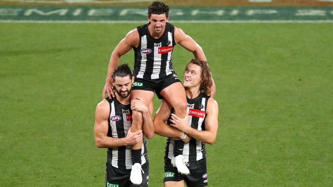 Brodie Grundy and Darcy Moore chair Pendles off the ground after the match. Picture: AFL Photos/Getty Images