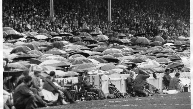 Crowd sheltering from the rain under umbrellas in the SANFL Grand Final match – between Sturt and Glenelg – at Adelaide Oval 26 Sep 1970.