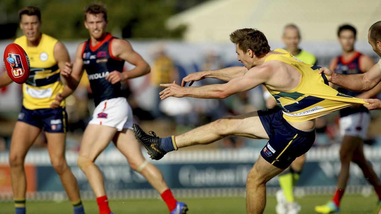 SANFL: Eagles v Norwood at Woodville Oval. Eagle's Louis Sharrad kicks towards goal while being dragged by Norwood's Jace Bode.18 May 2019. (AAP Image/Dean Martin)