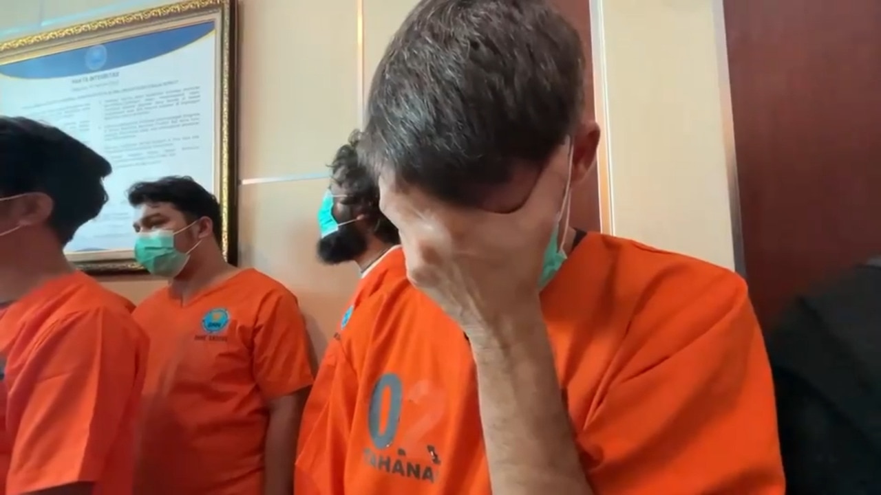 Aussie accused hides face at police show drug haul