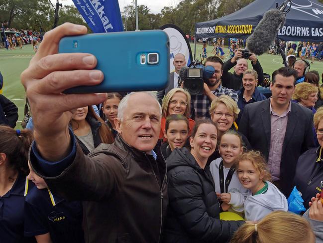 Australian Prime Minister Malcolm Turnbull shares takes a selfie with young netball players during visit to the HE Parker Netball Complex in Melbourne East, Saturday, June 18, 2016. (AAP Image/Lukas Coch)