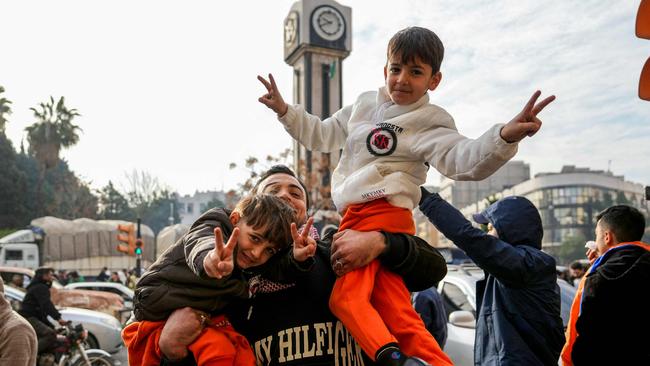 Syrians celebrate near the Clock Tower in the central city of Homs on December 8. Picture: Muhammad Haj Kadour/AFP