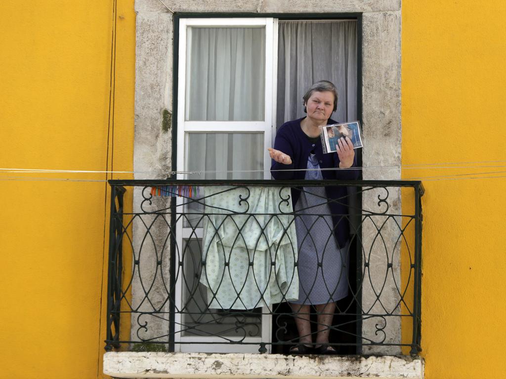 A local resident in Lisbon gets a face mask delivered from church members. Picture: AP Photo/Armando Franca.