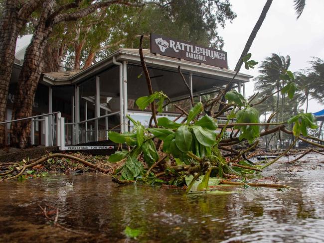 A bar restaurant is seen past fallen branches in Palm Cove as Cyclone Jasper approaches landfall near Cairns in far north Queensland on December 13, 2023. A tropical cyclone was building strength as it rolled towards northeastern Australia on 13 December, with authorities warning "life-threatening" floods could swamp coastal regions for days. (Photo by Brian CASSEY / AFP)