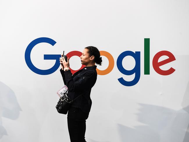 (FILES) In this file photo taken on May 16, 2019 a woman takes a picture with two smartphones in front of the logo of the US multinational technology and Internet-related services company Google as he visits the Vivatech startups and innovation fair, in Paris. - Google parent Alphabet's stock price leapt July 25, 2019, after reporting stronger-than-expected results in a quarterly update coming amid growing scrutiny of technology firms by antitrust regulators. (Photo by ALAIN JOCARD / AFP)