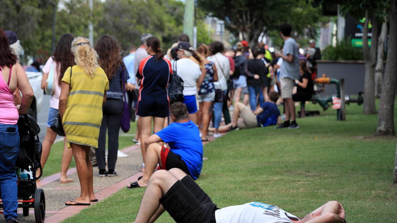 Lines of people wait at Southport Centrelink. Picture: Adam Head.