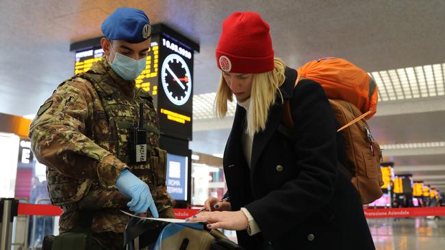 An Italian Army officer checks a passenger at the Rome Termini railway station, to make sure that she is not violating quarantine. Picture: Getty