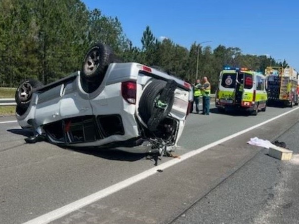 The Bruce Hwy is closed at Coochin Creek after a two-vehicle crash where one car rolled.