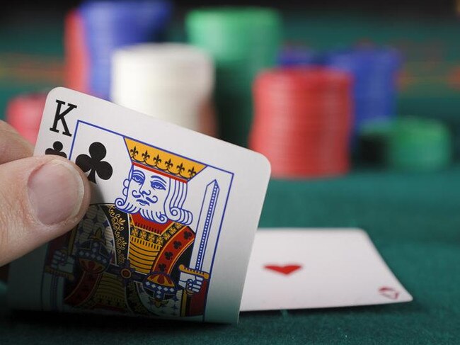 A close-up of a player's hand in a card game of blackjack.