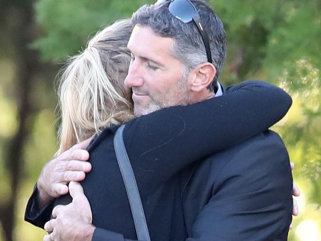 Aaron Cockman (right) is greeted by family and friends outside Bunbury Crematorium before the funerals of his ex-wife Katrina Miles and their four children. Picture: AAP /Richard Wainwright