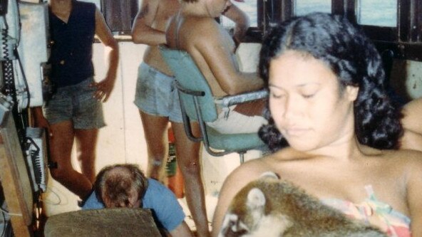 On the bridge of the MV Debut in the early 1980s. Dick Brooks' wife Mariana is holding a monkey called Bear. The skipper ended up killing the monkey to stop it biting baby Robbie while the ship was stranded on Emily Reef. Picture: Supplied