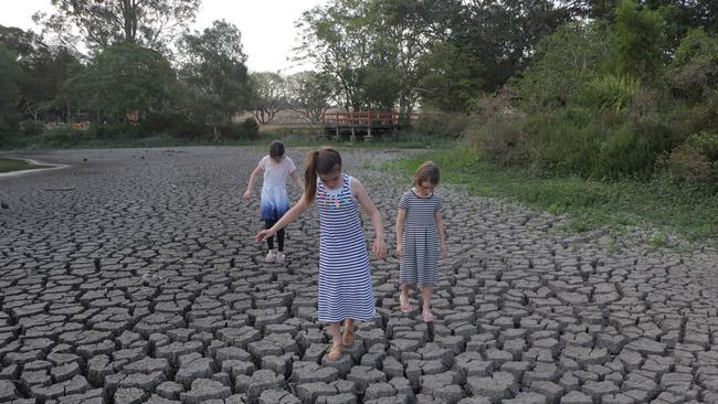 Children walking over the dry lake bed at Biami Yumba before rain partially filled it.