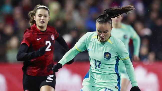 LANGFORD, BRITISH COLUMBIA - DECEMBER 01: Cloe Lacasse #20 and Sydney Collins #2 of Canada look on as Amy Sayer #17 of Australia plays the ball during the first half of their friendly match at Starlight Stadium on December 01, 2023 in Langford, British Columbia. (Photo by Jeff Vinnick/Getty Images for Football Australia)