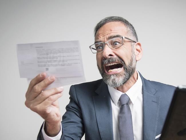 Furious business man shocked and angry with expensive bills he receives at his office, electricity money generic