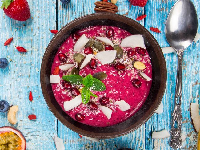 Smoothie bowl with fresh berries, nuts, seeds, fruit and vegetables. Healthy breakfast.