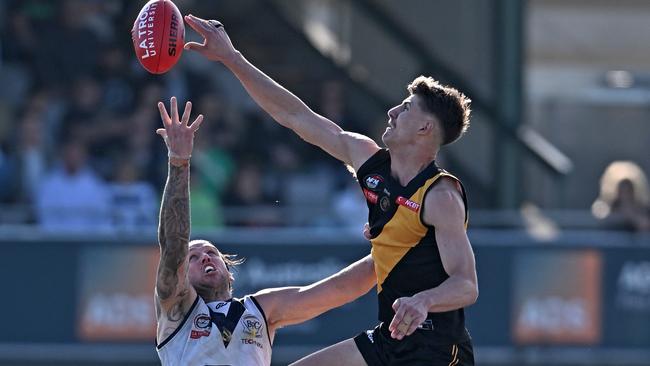 Heidelberg’s Mitch Jorgensen jumps over Bundoora’s Hamish Shepheard. Picture: Andy Brownbill