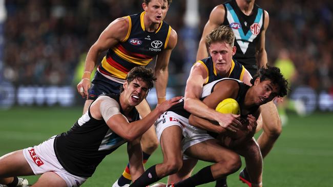 ADELAIDE, AUSTRALIA - MAY 02: Brayden Cook of the Crows tackles Jase Burgoyne of the Power during the 2024 AFL Round 08 match between the Adelaide Crows and the Port Adelaide Power at Adelaide Oval on May 02, 2024 in Adelaide, Australia. (Photo by James Elsby/AFL Photos via Getty Images)