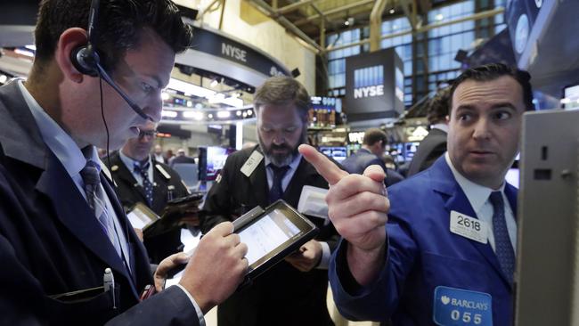 Specialist James Sciulli, right, works with traders on the floor of the New York Stock Exchange, Friday, Oct. 23, 2015. Technology shares are surging in early trading after several big-name companies reported big earnings gains. (AP Photo/Richard Drew)