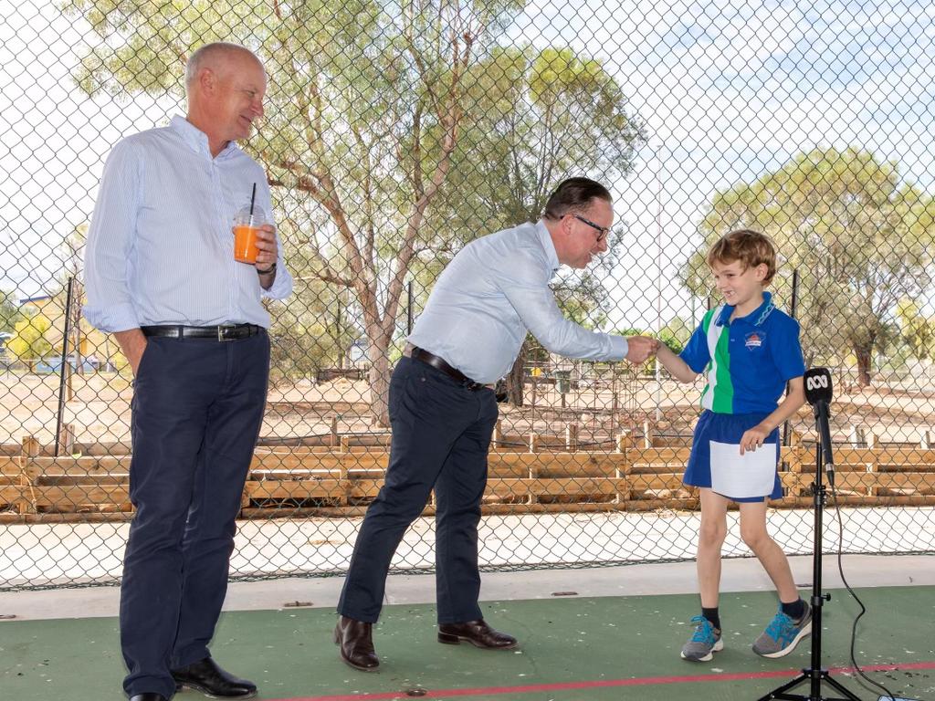 CEO Alan Joyce shakes the hand of a local school student George whilst Qantas Chairman Richard Goyder looks on