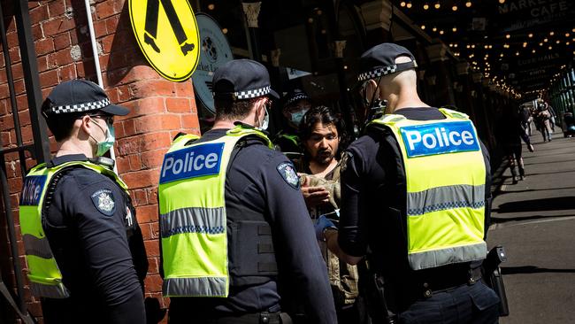 Police confront a maskless anti-lockdown protester in September 2020. Photo: Getty