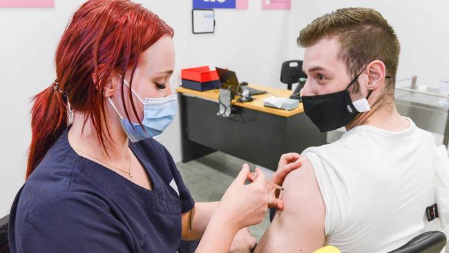 SA Health vaccinator Tayla gives MSS Medical hotel security team leader Aiden Wilson a Covid booster vaccine at Wayville in November. Picture: NCA NewsWire/Brenton Edwards