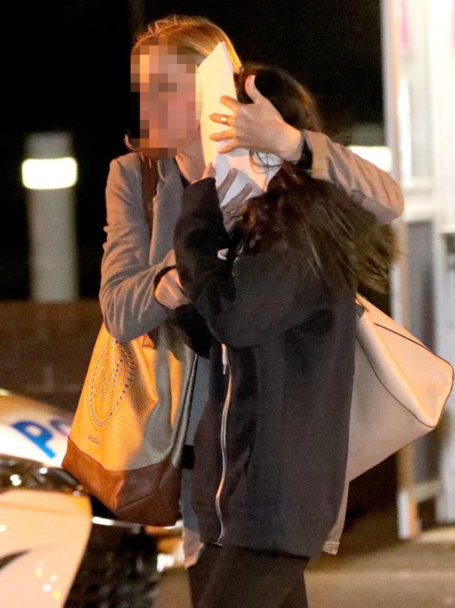 The mother shielded her daughter’s face as they left the police station. Picture: Damian Shaw
