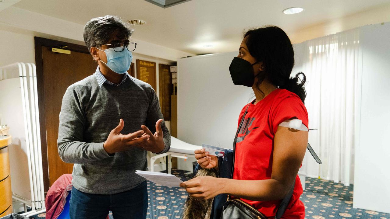 A member of the public holds her vaccination card after receiving a dose of a Covid-19 vaccine in north west London on December 26. Picture: Niklas Halle’n/AFP