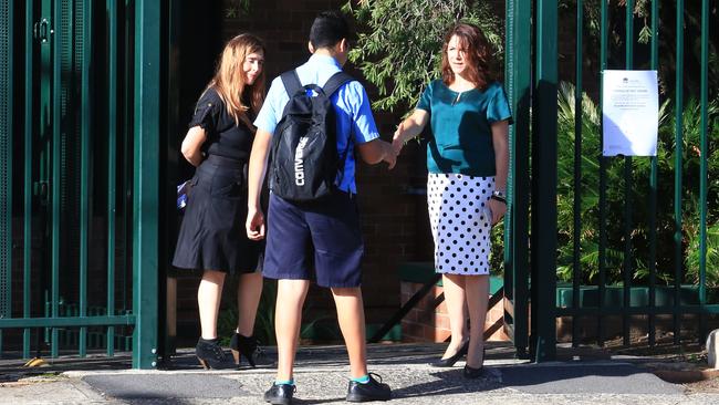 A student shakes hand with a female teacher at the school. Picture: Adam Taylor