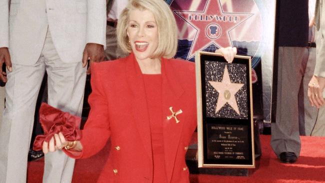 Joan Rivers poses next to her star on the Hollywood Walk of Fame during her induction ceremony in Los Angeles.