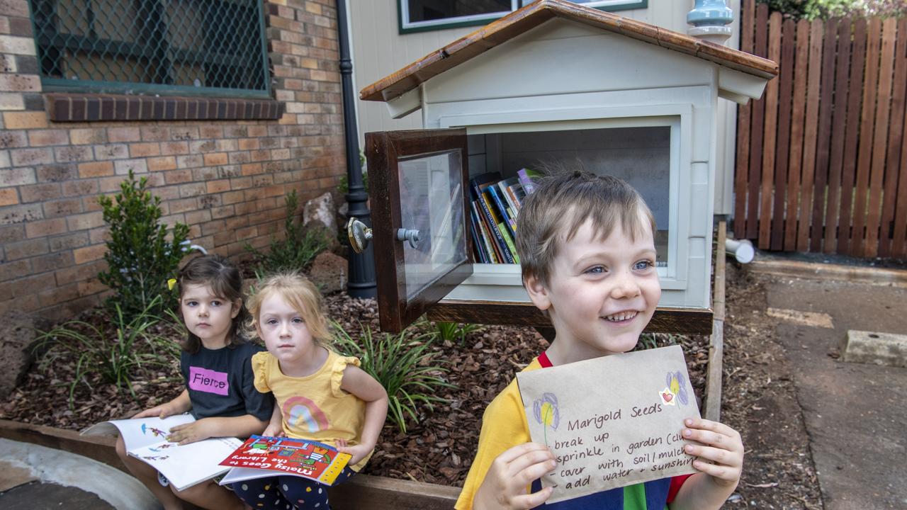 Kindy students (from left) Ruby Inglis, Macie Crawford and Harrison Schmidt from Rosemont Cottage in front of their new street library. Picture: Nev Madsen